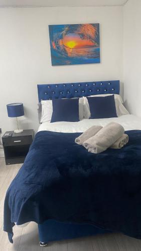 ein Schlafzimmer mit einem blauen Bett mit blauer Decke in der Unterkunft BV Royal Comfy Studio Seven Suite Queensgate Huddersfield in Huddersfield