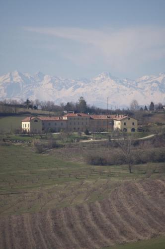 a group of buildings in a field with mountains in the background at La Famulenta 17 in Grazzano Badoglio