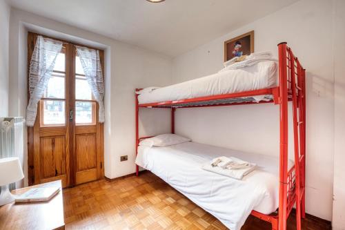 Ce dortoir comprend 2 lits superposés et une fenêtre. dans l'établissement Incanto Walser Apartments Piazza, à Macugnaga