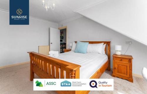 a bedroom with a wooden bed and a night stand at DUPLEX - INVOICE and REDUCED PRICE only via SUNRISE SHORT LETS DUNDEE, 5 Bed Rooms, Amazing Views, Fully Equipped, Free Parking, WiFi, FAVOURITE for Groups & Businesses, Food, Bars, Shops, Library, River Views, and ONLY 5 Mins to STANNERGATE Ports in Dundee