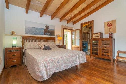 Un dormitorio con una cama y suelo de madera. en Son Arboç Gran, en Algaida