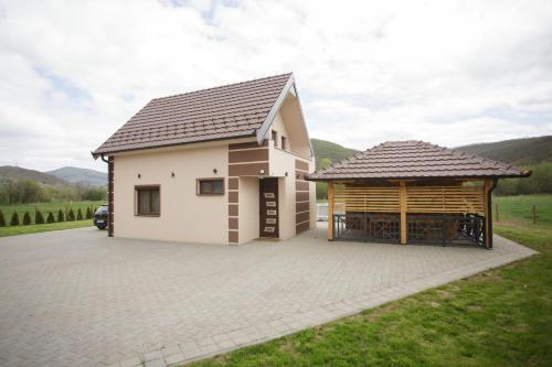 a small white house with a large driveway at Vila Oaza mira Draganići in Raška