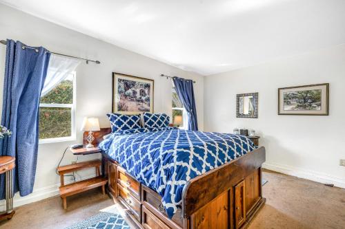 a bedroom with a bed with a blue and white comforter at Mendocino Dunes - Sand Dollar in Fort Bragg