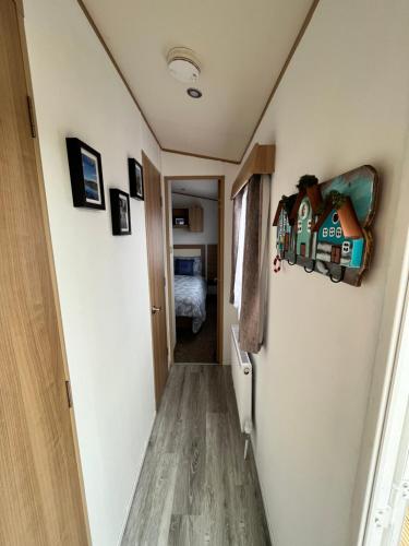 a hallway leading to a bedroom with a house on the wall at JS Holidays Tebay Lagganhouse in Ballantrae