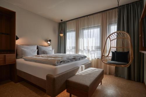 ein Schlafzimmer mit einem Bett, einem Stuhl und einem Fenster in der Unterkunft Cocoon Salzburg in Salzburg