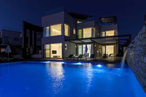 a villa with a swimming pool at night at Beachfront Luxury Villa Glory in Ayia Napa