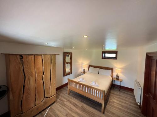 a bedroom with a bed and a large wooden closet at Anne's Cottage in Bargrennan