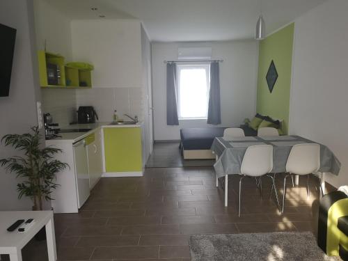 a kitchen and a living room with a table and chairs at Villa Balifornia in Balatonboglár