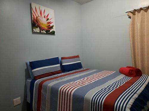 ein Schlafzimmer mit einem Bett mit einer bunten gestreiften Decke in der Unterkunft The Dolphin View 4 in Langstrand