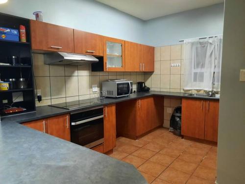 a kitchen with wooden cabinets and a microwave at The Dolphin View 4 in Langstrand