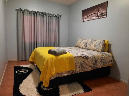 Un dormitorio con una cama con una manta amarilla. en The Dolphin View 4 en Langstrand