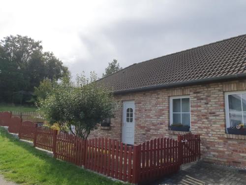 a brick house with a red fence at Ferienwohnungen Rügen-Glück in Lohme