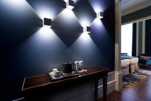 une chambre avec des murs bleus et des lumières sur une table dans l'établissement ICON Duplo Ribeira, à Porto