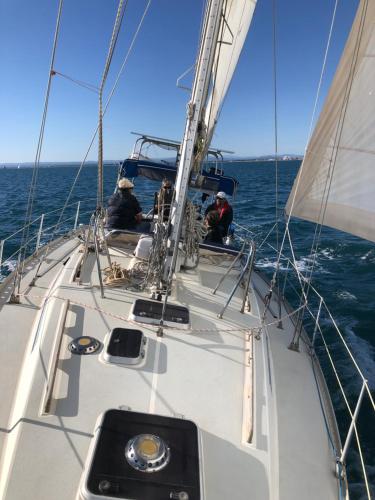 un grupo de personas en un velero en el océano en Location insolite en voilier, navigation, coucher de soleil, et baignades en mer, en Le Grau-du-Roi