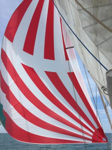 una vela roja y blanca en un barco en Location insolite en voilier, navigation, coucher de soleil, et baignades en mer, en Le Grau-du-Roi