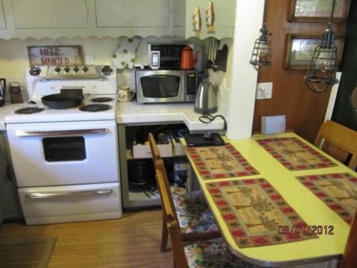 a kitchen with a white stove and a table at Historical Cabin in Julian Pet's okay! in Julian