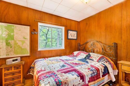 a bedroom with wooden walls and a bed and a window at Historical Cabin in Julian Pet's okay! in Julian