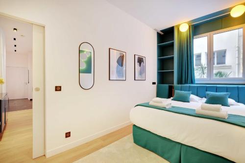 パリにあるCMG マレ レピュブリック Fのベッドルーム1室(ブルーアクセントの大型ベッド1台付)