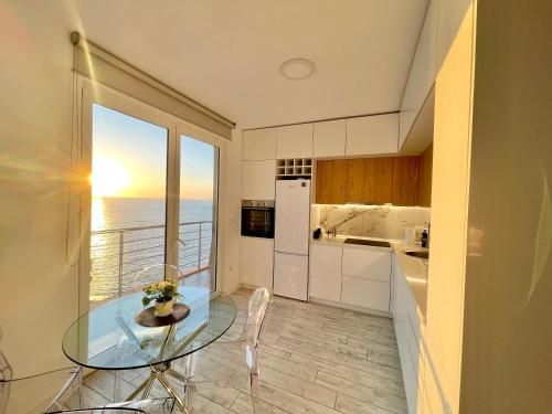 - une cuisine avec une table en verre et une vue sur l'océan dans l'établissement Durres Currila Modern Luxury STUNNING Beach Views, à Durrës