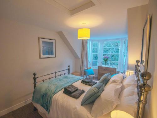 a bedroom with a bed with pillows and a window at Forth Reflections in Queensferry