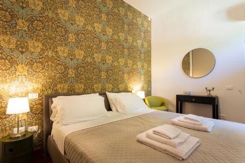 ペルージャにあるAppia Apartment - Relax & Spa - Centro Storicoのベッドルーム1室(ベッド1台、タオル2枚付)