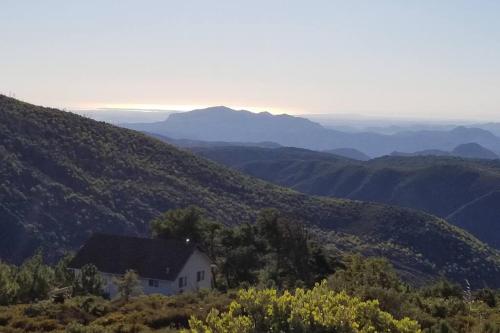 a house on the side of a hill at A LIVING CANVAS Amazing Lake View Custom Home in Julian