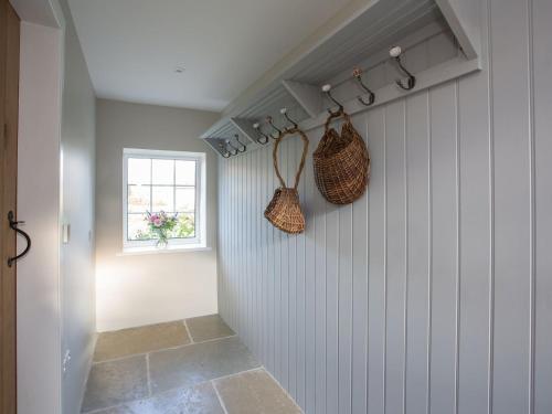 a hallway with baskets on the wall and a window at Lyndhurst Cottage in Carlton