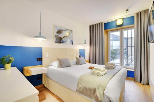 a bedroom with a large bed with blue walls at CMG Marais // République G in Paris