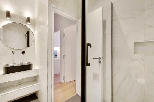 une salle de bain avec un lavabo et un miroir dans l'établissement Spacious apartment - 2B-10P - AC - Marais, à Paris