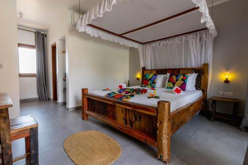 a bedroom with a large wooden bed in a room at Aluna Paje in Paje