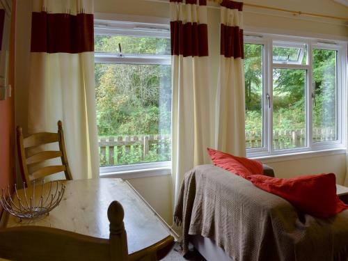 a room with a bed and a table and windows at Satchwell - Uk31538 in Kirkhill