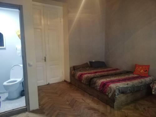 a small bedroom with two beds and a toilet at Jessi on Marjanishvili in Tbilisi City
