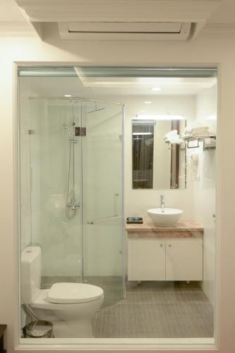 a bathroom with a shower and a toilet and a sink at Mercy Hotel in Hanoi