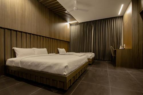 sypialnia z 2 łóżkami w pokoju z drewnianymi ścianami w obiekcie RATHNA RESIDENCY - Near US CONSULATE w mieście Ćennaj