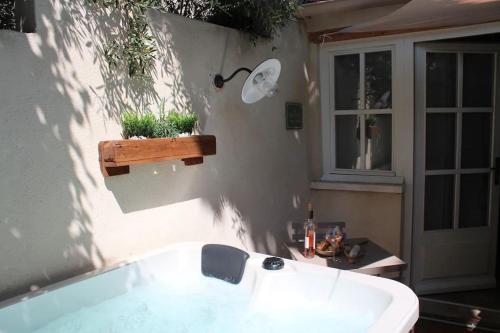 a white bath tub sitting next to a house at LA PETITE MAISON DE MAUSSANE *** in Maussane-les-Alpilles