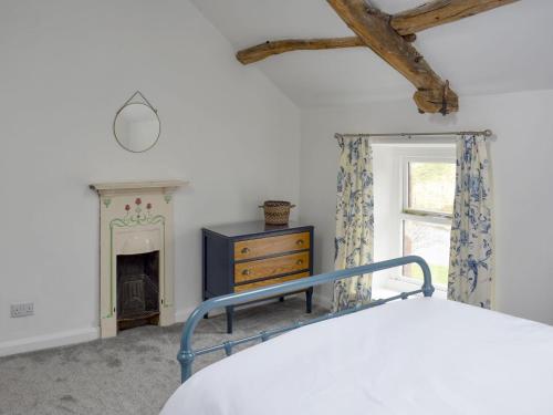 - une chambre avec un lit et une cheminée dans l'établissement Toms Cottage, à Melmerby