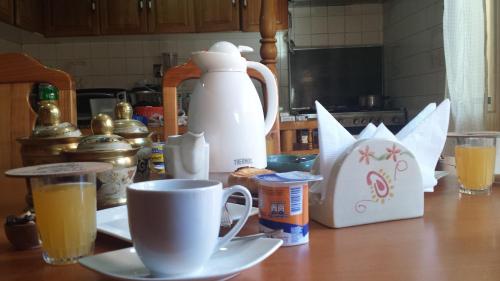 Una mesa con una cafetera y tazas. en Hostal Parediso, en Punta Arenas