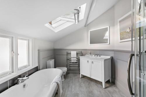 a bathroom with a tub and a toilet and a sink at 1 Quayside in Appledore