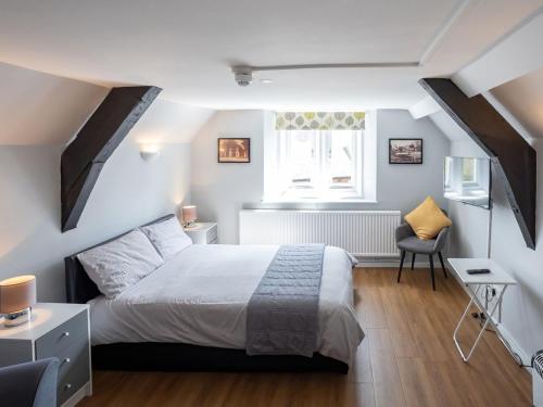 a bedroom with a white bed and a window at The Coach House Apartment in Edwinstowe