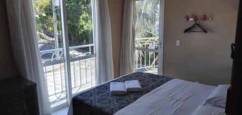 1 dormitorio con 1 cama y 2 toallas blancas en Hotel Hola, en Florianópolis