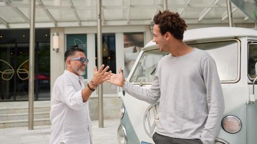a man giving another man a high five in front of a van at Cocoon Salzburg in Salzburg