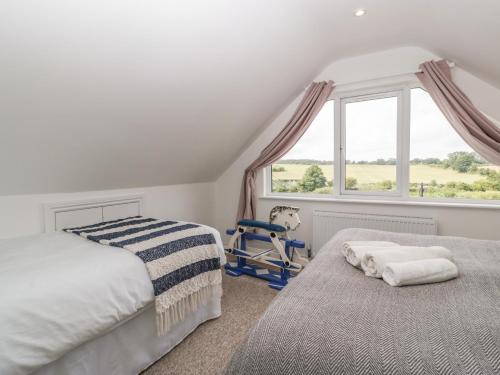 a bedroom with a bed and a chair and a window at Highbank in Wareham