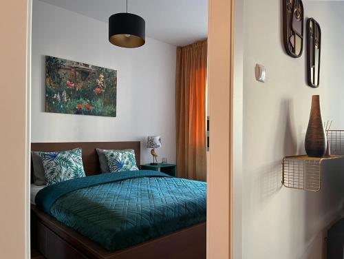 a bedroom with a bed with a green comforter at Elegant and comfortable apartment Warsaw in Warsaw