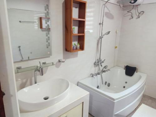 ein Badezimmer mit einem Waschbecken, einer Badewanne und einem WC in der Unterkunft Hotel SU kataragama in Kataragama