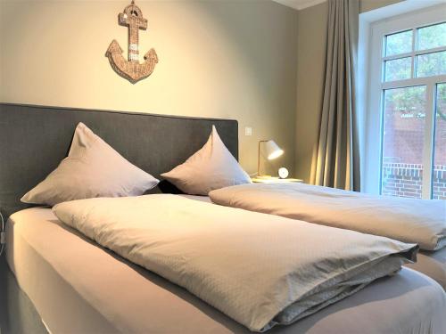 a bedroom with two beds with a cross on the wall at Ferienwohnung Strandmuschel in Wangerooge