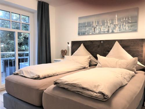 dos camas sentadas una al lado de la otra en un dormitorio en Ferienwohnung Inselherz, en Wangerooge