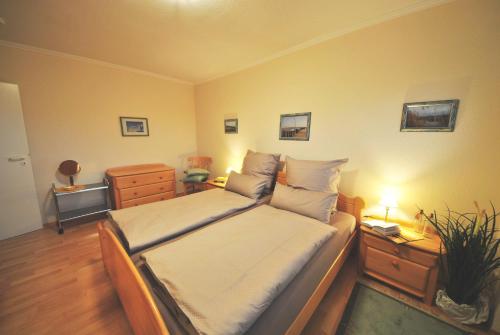 1 dormitorio con 1 cama y vestidor con mesita de noche en Ferienwohnung am Damenpfad en Wangerooge