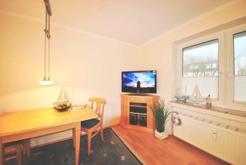 uma sala de estar com uma mesa de jantar e uma televisão em Ferienwohnung am Damenpfad em Wangerooge