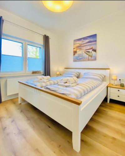 a large white bed in a room with two windows at Dünenhaus Ferienwohnung De Düün Dree in Wangerooge