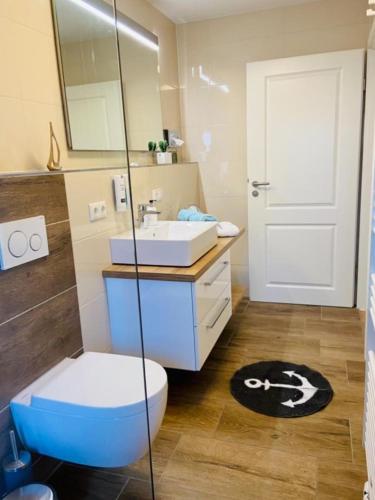 a bathroom with a toilet and a sink and a mirror at Dünenhaus Ferienwohnung De Düün Dree in Wangerooge